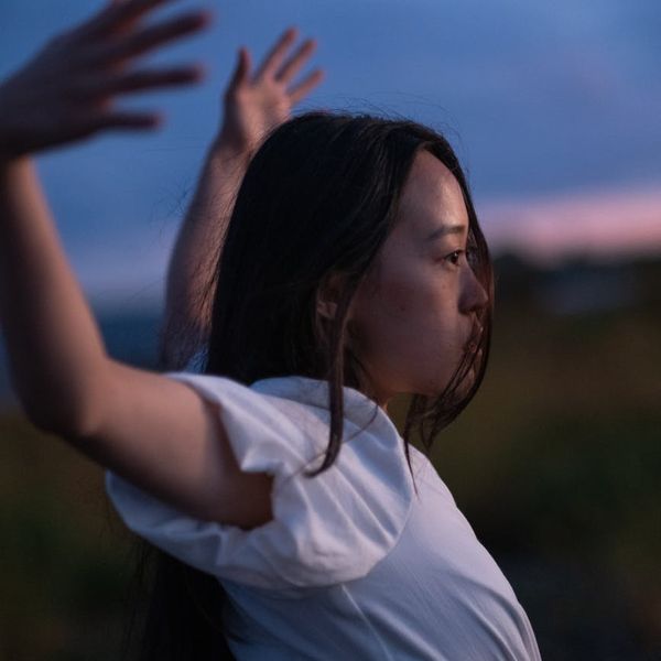 Person stretching outdoors with a serene landscape in the background.